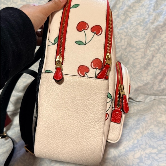 cherry backpack coach Court With Heart Print Signature coated canvas and smooth leather Zip closure fabric lining Outside zip pocket Attached split key ring and dogleash clip 3 1/4 (L) x 4 (H) x 1 1/2 (W) Style No. Cherry print coach backpack |